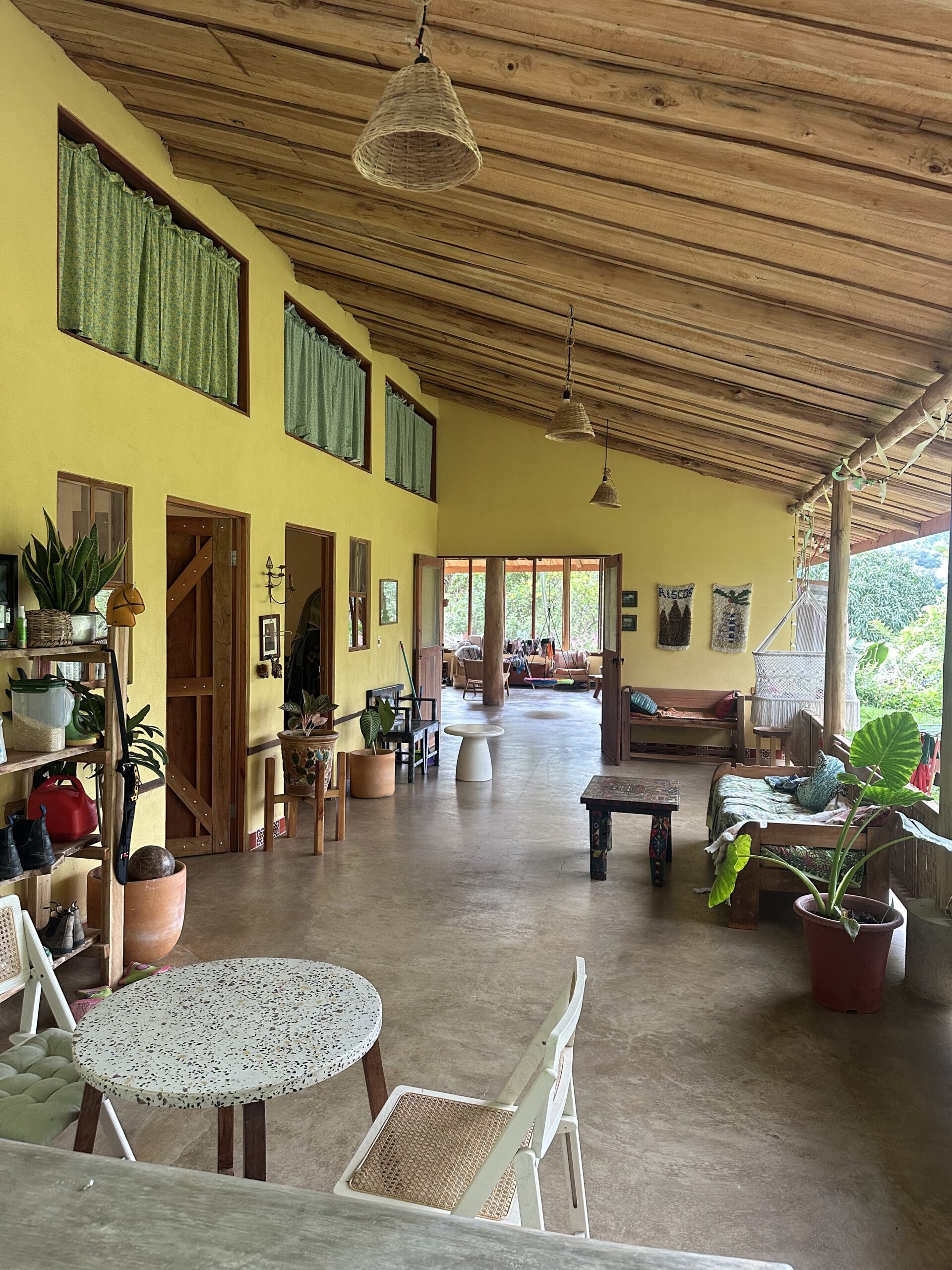 Long covered living area with a timber ceiling in a completed home in Puriscal