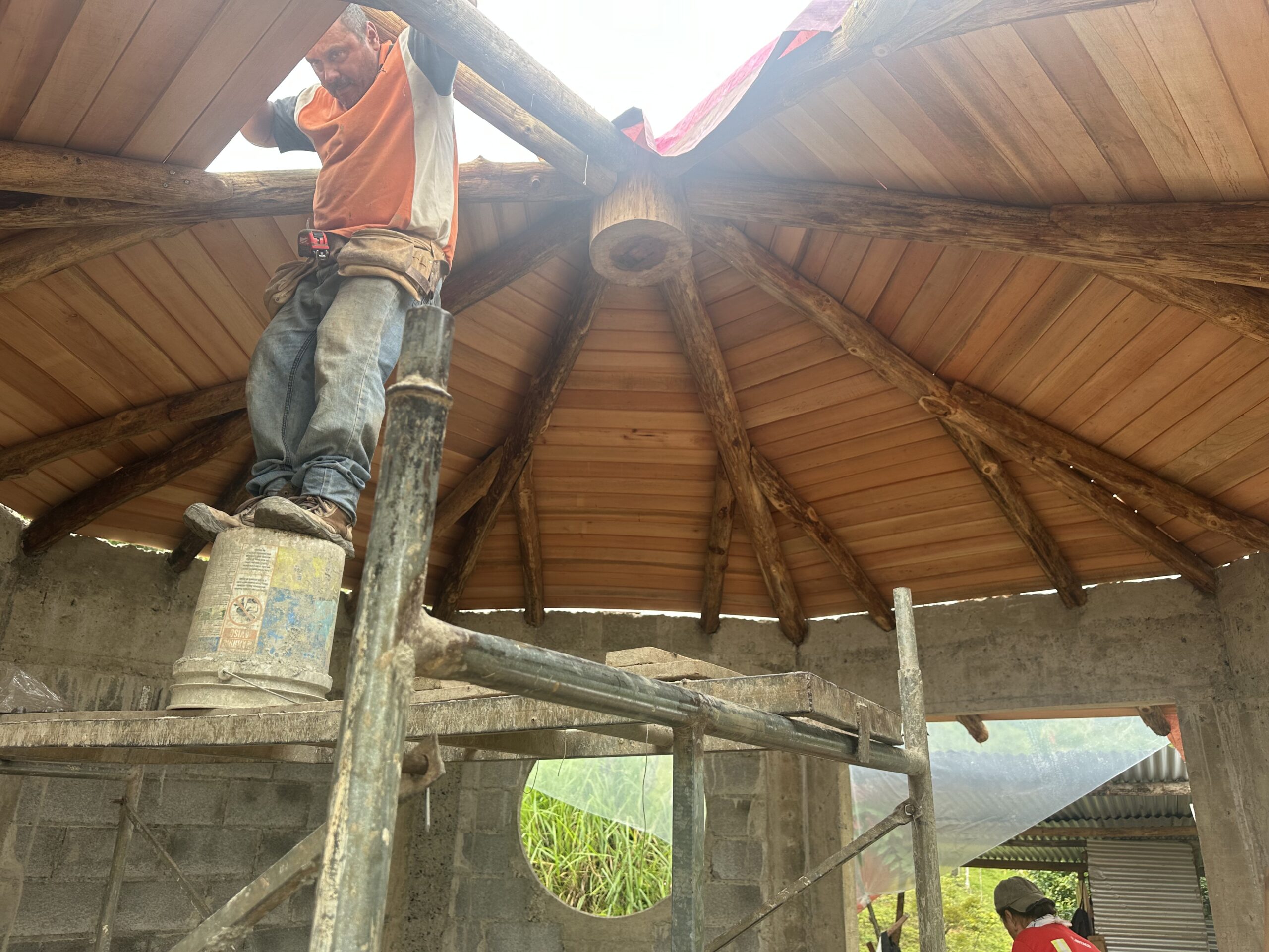 Craftsman working beneath a radial roof made from round timbers