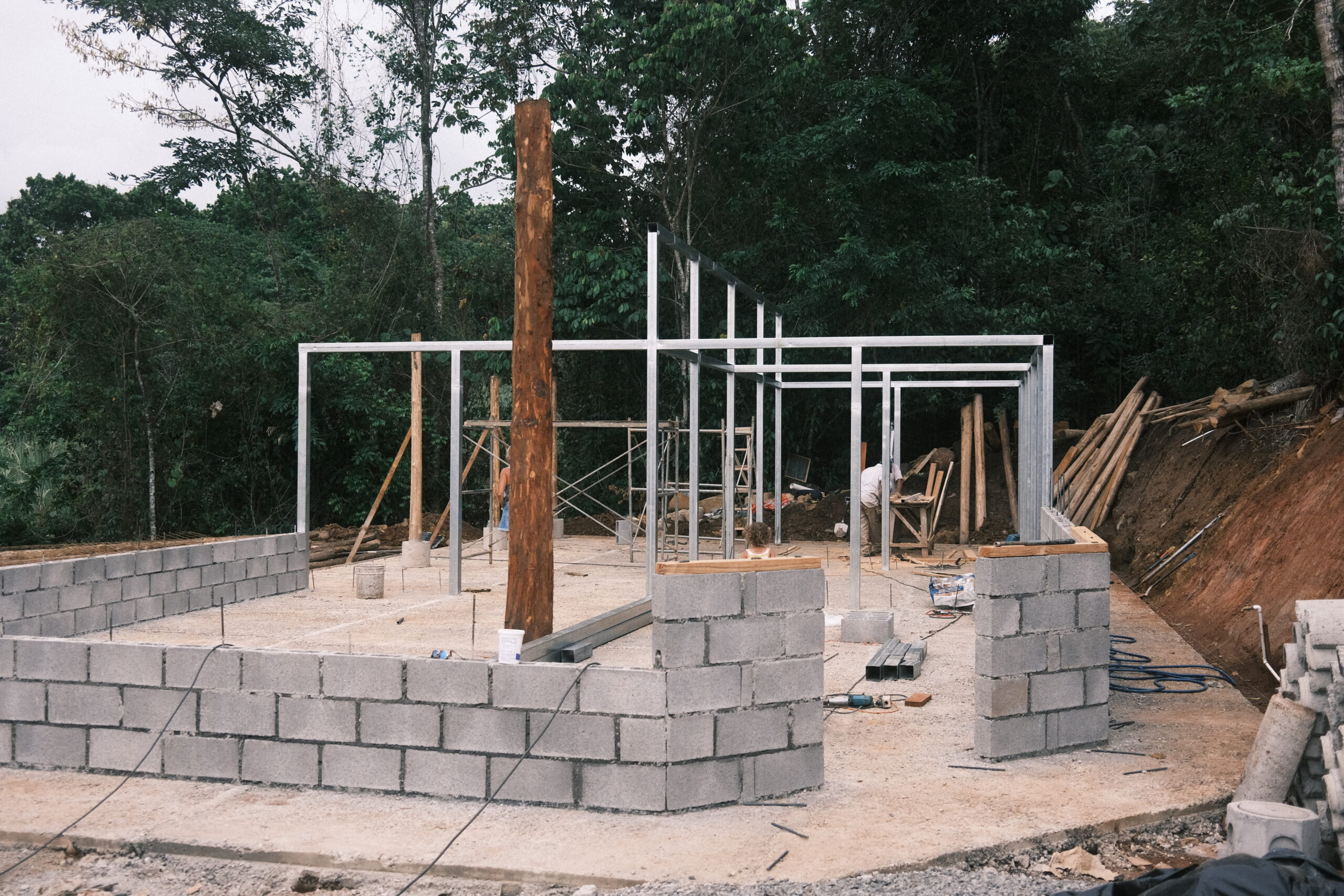 Steel frame, masonry walls, and a central timber post during construction