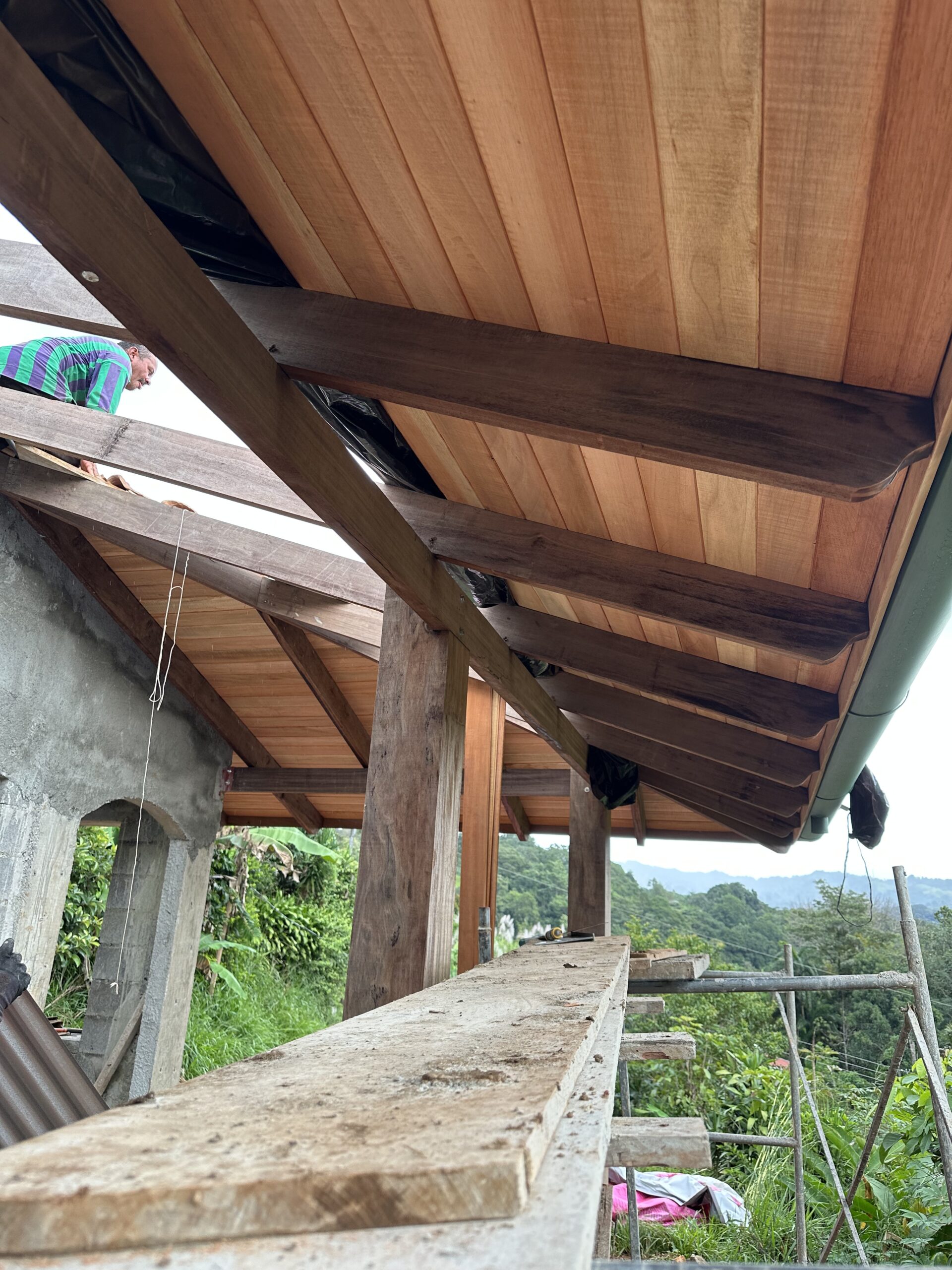 Craftsman installing timber boards beneath the roof