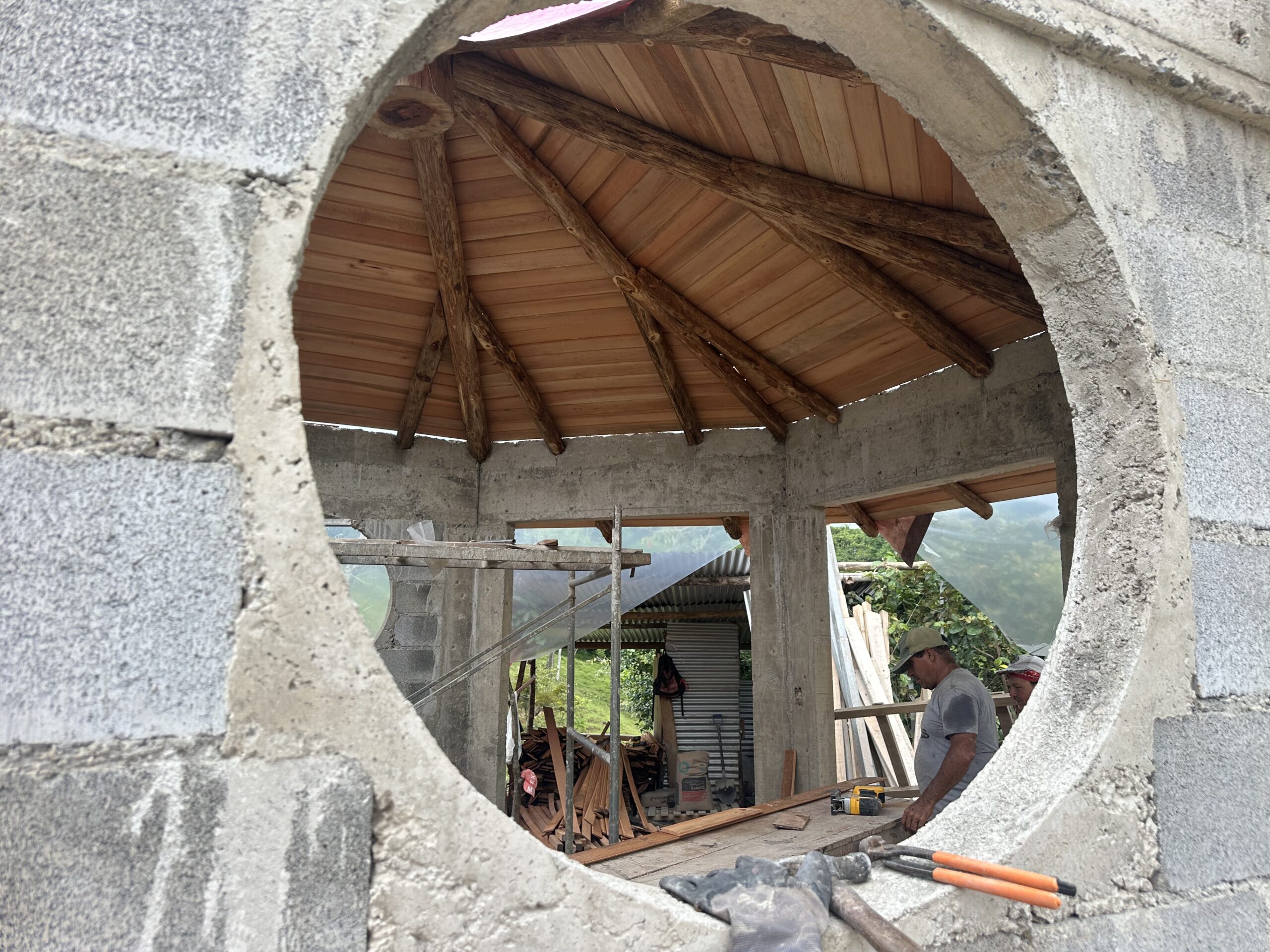 Radial timber roof seen through a large circular masonry opening
