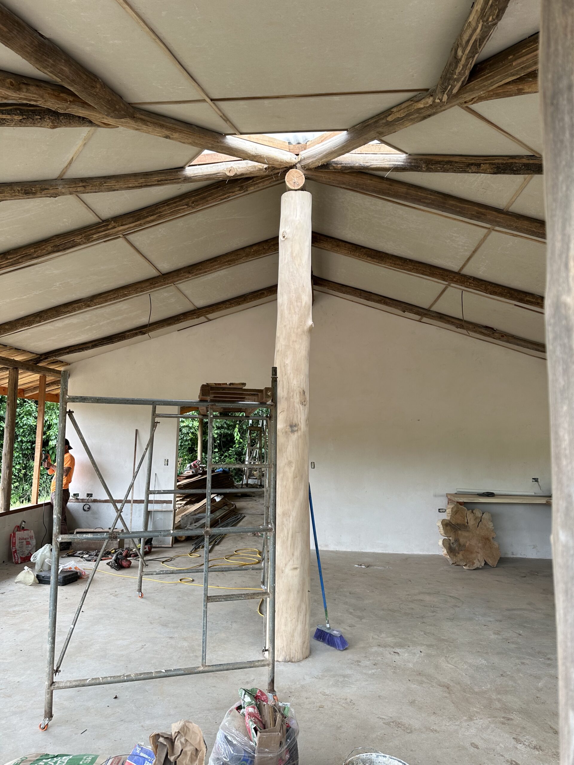 Interior construction showing exposed beams and a central round timber column