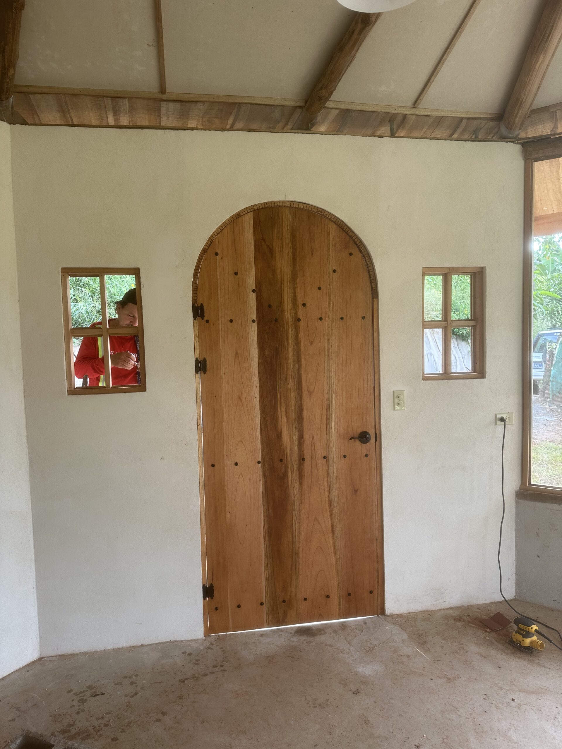Handmade arched timber door being installed during construction