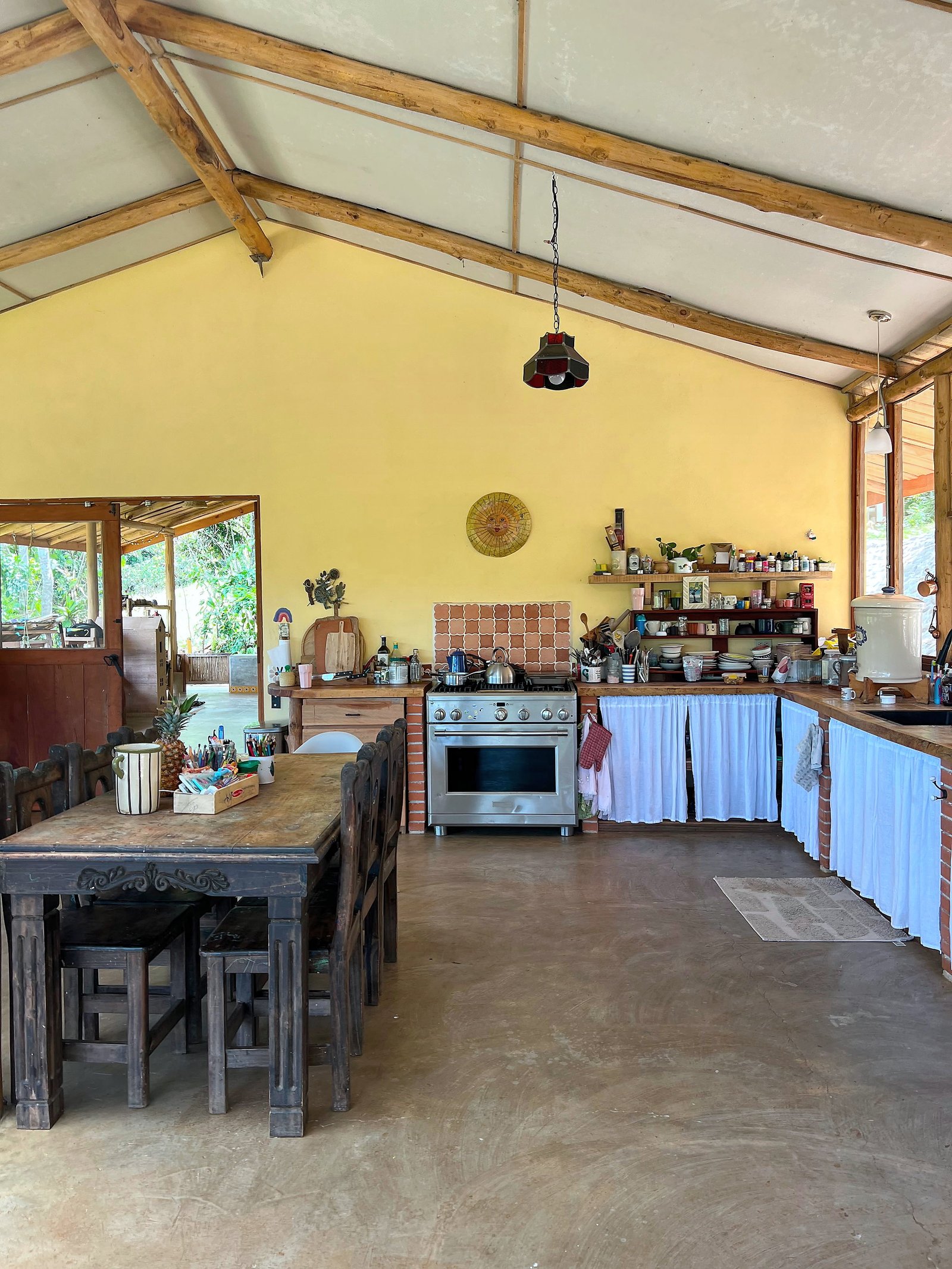 Family kitchen with exposed timber beams, open shelving, and handmade details
