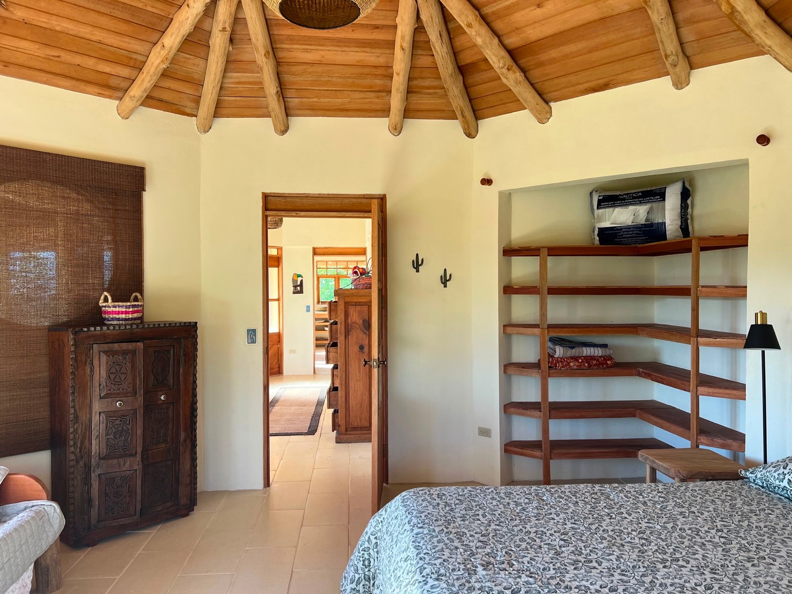Bedroom with exposed round timber roof and built-in shelving